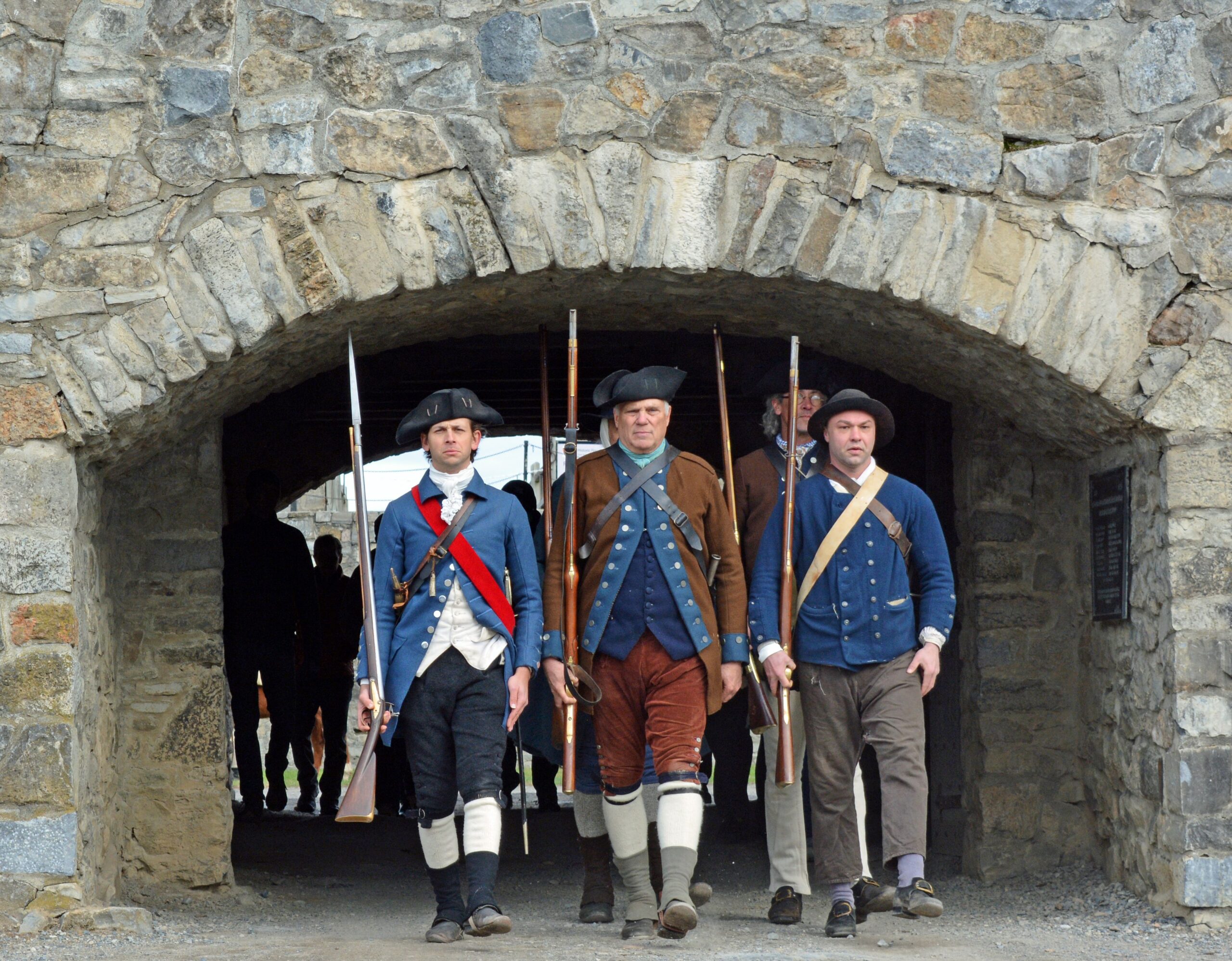 soldiers marching through archway